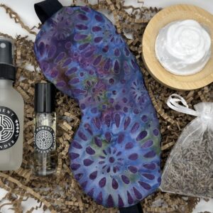 a spa gift set containing a lavender sleep mask, lavender essential oil, lavender mist, a lavender sachet, and a lavender shower steamer